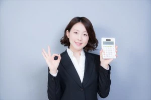 電卓を持ちOKサインをする女性