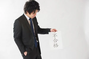 不合格通知を持つ男性