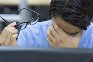目を押さえる男性