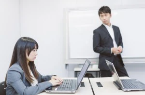 PCに向かう生徒と見守る講師